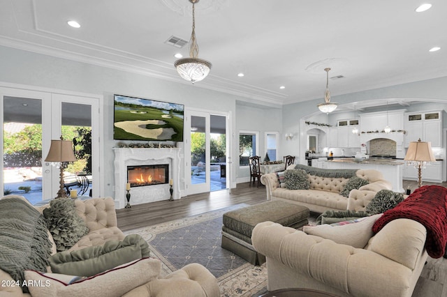 living room with crown molding, french doors, a high end fireplace, and dark hardwood / wood-style floors