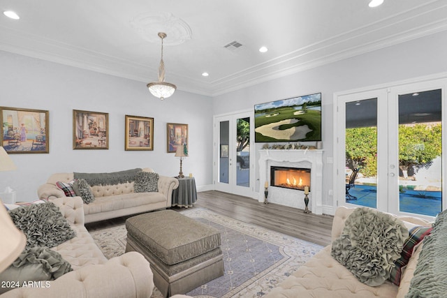 living room with a fireplace, french doors, crown molding, and wood-type flooring