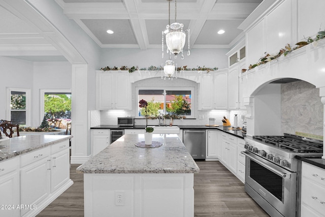 kitchen featuring coffered ceiling, decorative light fixtures, decorative backsplash, a kitchen island, and appliances with stainless steel finishes