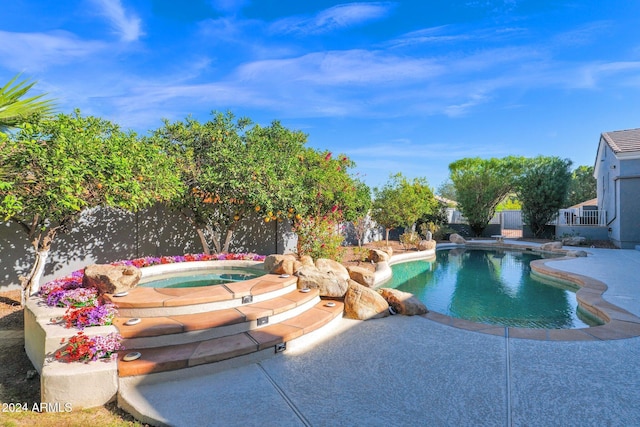 view of swimming pool featuring a patio area and an in ground hot tub