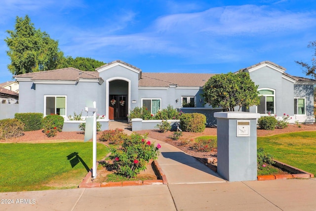 mediterranean / spanish-style home with a front lawn