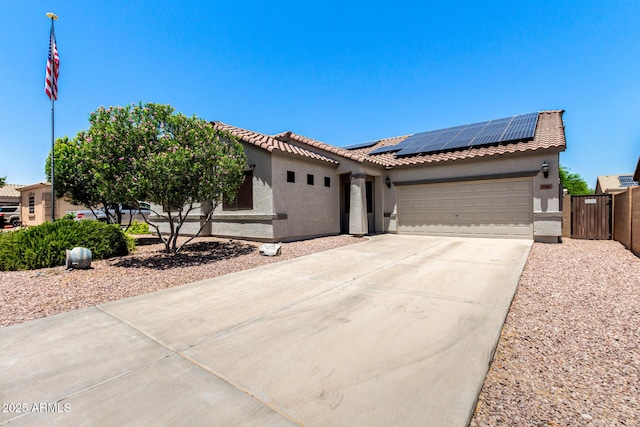 17562 W Gelding Dr, Surprise, AZ 85388 - view of front of home featuring roof mounted solar panels, stucco siding, a garage, driveway, and a tiled roof