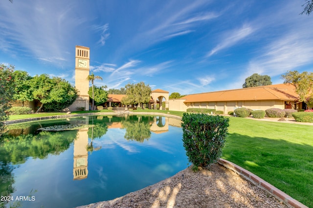 view of swimming pool featuring a lawn and a water view