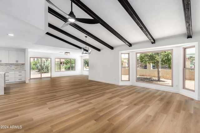 unfurnished living room with vaulted ceiling with beams, light hardwood / wood-style flooring, and ceiling fan