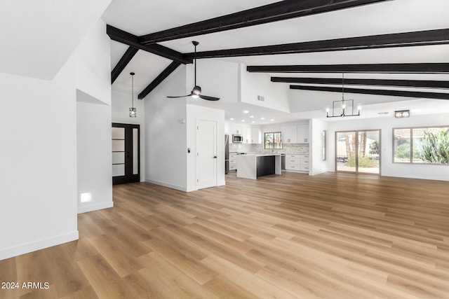 unfurnished living room with vaulted ceiling with beams, light hardwood / wood-style floors, and ceiling fan with notable chandelier