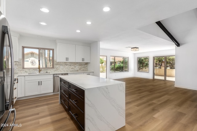 kitchen featuring a center island, stainless steel appliances, plenty of natural light, and light wood-type flooring