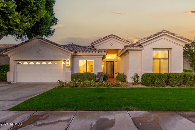 mediterranean / spanish-style home featuring a yard and a garage