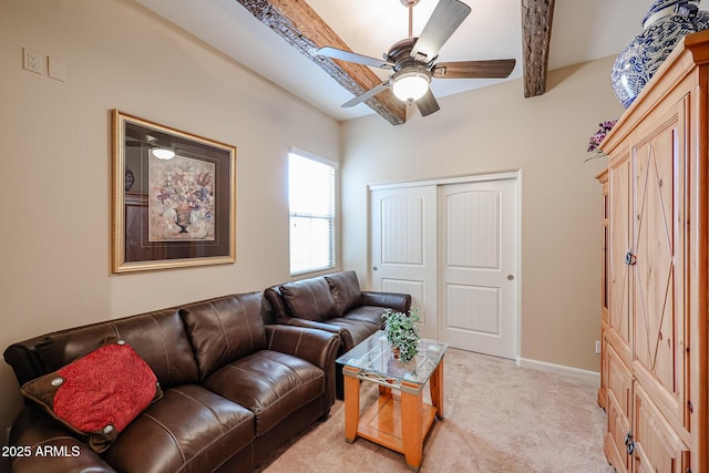 living area with light colored carpet, baseboards, and a ceiling fan
