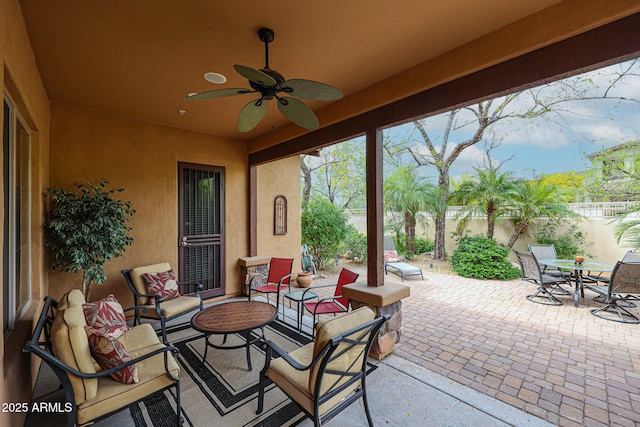 view of patio with fence, outdoor dining area, and ceiling fan