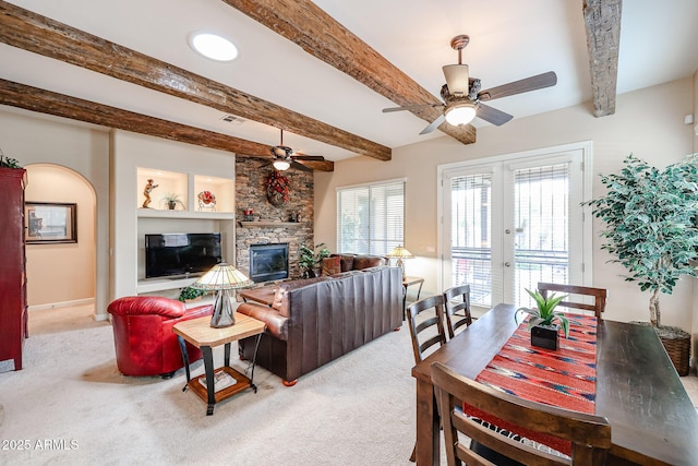 carpeted living room with beamed ceiling, a fireplace, and ceiling fan