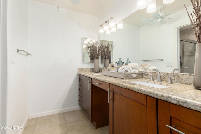 9809 W Behrend Dr, Peoria, AZ 85382 - full bath featuring ceiling fan, double vanity, tile patterned flooring, baseboards, and a shower with door