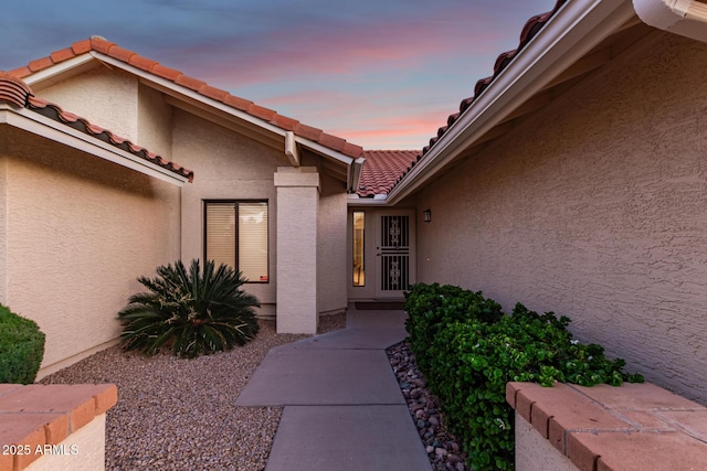 9809 W Behrend Dr, Peoria, AZ 85382 - exterior entry at dusk with a tile roof and stucco siding