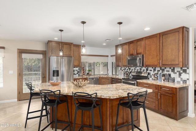 9809 W Behrend Dr, Peoria, AZ 85382 - kitchen featuring stainless steel appliances, light tile patterned flooring, decorative backsplash, brown cabinets, and recessed lighting