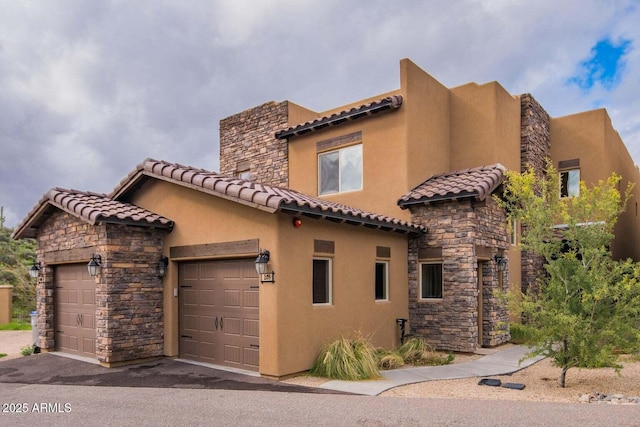 6145 E Cave Creek Rd Unit 203, Cave Creek, AZ 85331 - view of front facade with stucco siding, a tiled roof, stone siding, and a garage