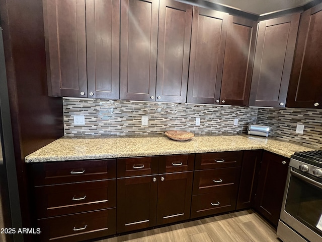 6145 E Cave Creek Rd Unit 203, Cave Creek, AZ 85331 - kitchen with gas range, light wood-style floors, backsplash, and light stone counters