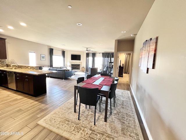 6145 E Cave Creek Rd Unit 203, Cave Creek, AZ 85331 - dining area featuring ceiling fan, a fireplace, light wood-type flooring, recessed lighting, and baseboards
