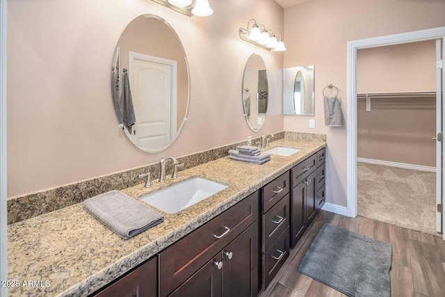 6145 E Cave Creek Rd Unit 203, Cave Creek, AZ 85331 - bathroom with double vanity, wood finished floors, a walk in closet, and baseboards