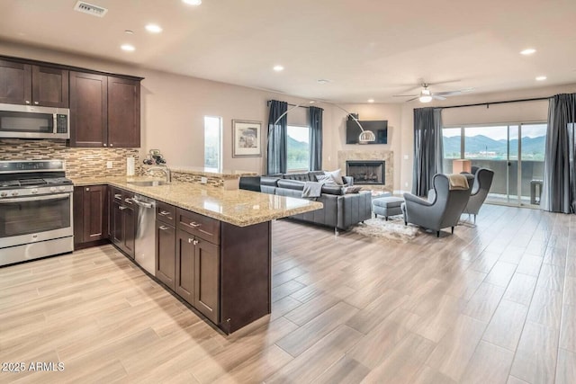 6145 E Cave Creek Rd Unit 203, Cave Creek, AZ 85331 - kitchen featuring stainless steel appliances, dark brown cabinetry, ceiling fan, a peninsula, and healthy amount of natural light