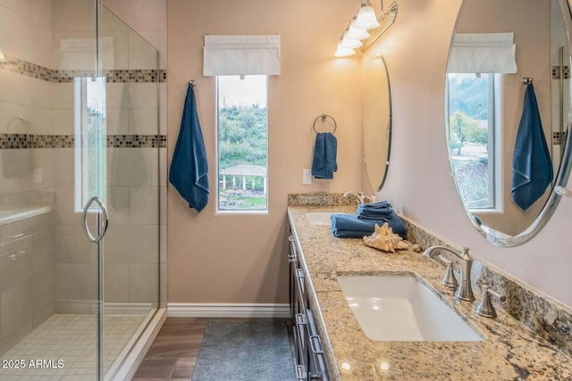 6145 E Cave Creek Rd Unit 203, Cave Creek, AZ 85331 - full bathroom featuring double vanity, a stall shower, wood finished floors, and baseboards
