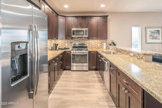 6145 E Cave Creek Rd Unit 203, Cave Creek, AZ 85331 - kitchen with stainless steel appliances, light stone counters, dark brown cabinetry, a sink, and tasteful backsplash
