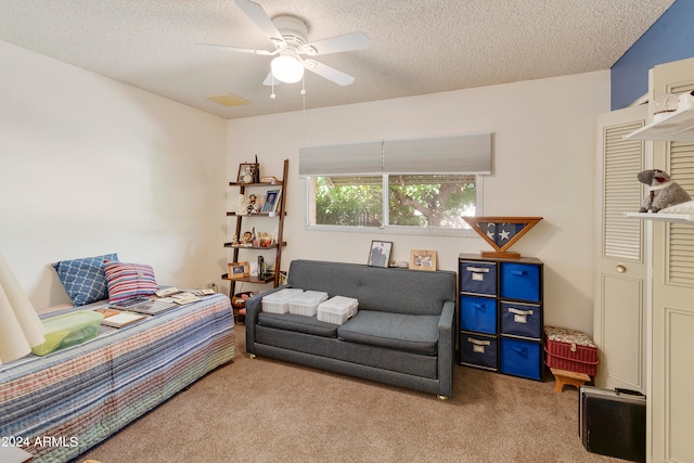 carpeted living room with a textured ceiling and ceiling fan