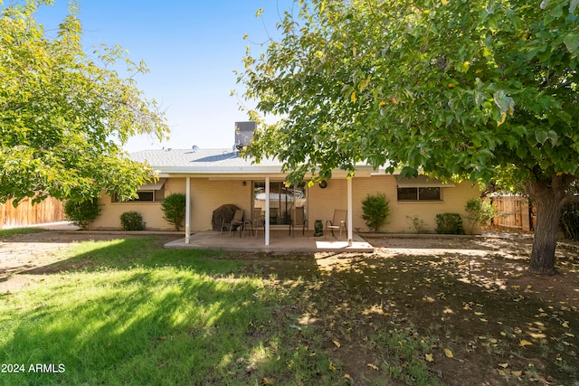 back of house with central AC unit, a lawn, and a patio