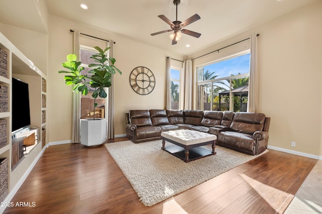 living room with wood-type flooring and ceiling fan