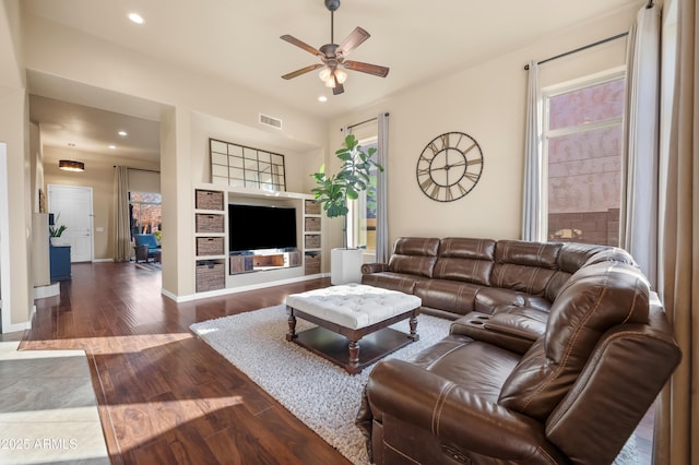 living room featuring ceiling fan and dark hardwood / wood-style flooring