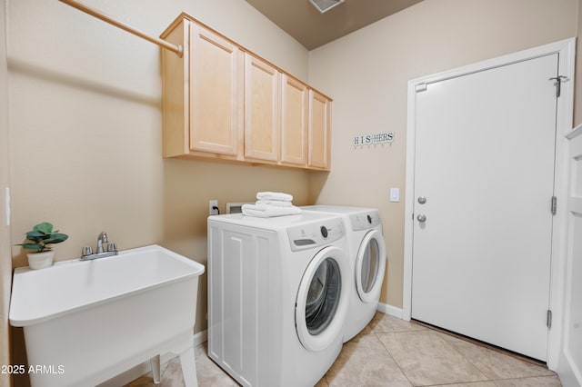 washroom with light tile patterned flooring, cabinets, washer and clothes dryer, and sink