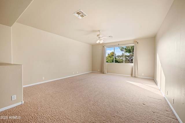 spare room featuring light colored carpet and ceiling fan