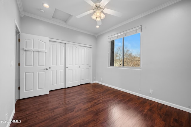 unfurnished bedroom with dark wood-type flooring, ornamental molding, a closet, and ceiling fan