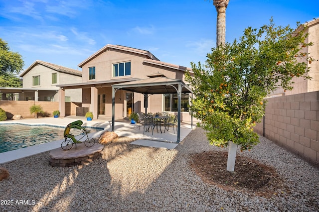 back of house with a fenced in pool, a gazebo, and a patio area