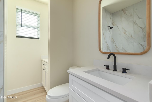 bathroom with hardwood / wood-style flooring, vanity, toilet, and walk in shower