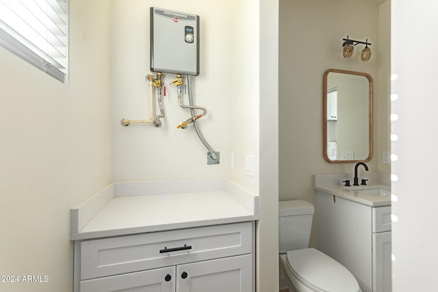 bathroom featuring water heater, vanity, and toilet