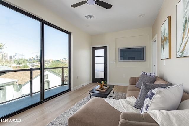 living room featuring a wealth of natural light, ceiling fan, and light wood-type flooring