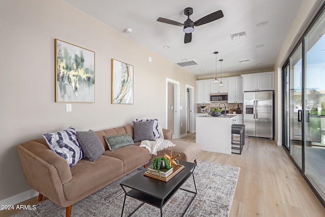 living room featuring light wood-type flooring and ceiling fan