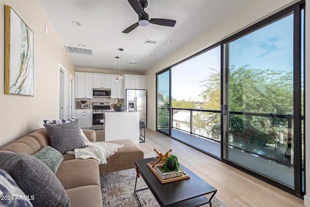 living room featuring light hardwood / wood-style floors and ceiling fan