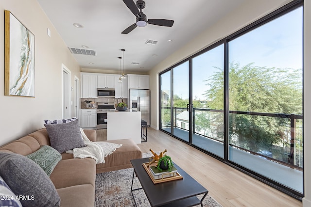 living room with light hardwood / wood-style floors and ceiling fan