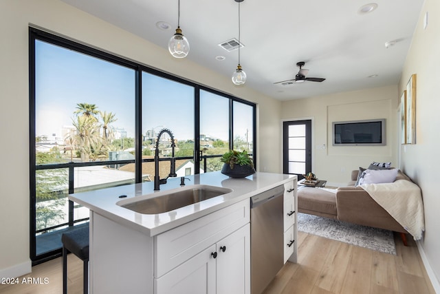 kitchen with stainless steel dishwasher, sink, light hardwood / wood-style floors, and white cabinets