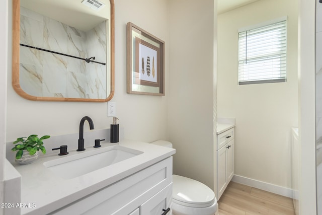 bathroom with walk in shower, wood-type flooring, vanity, and toilet