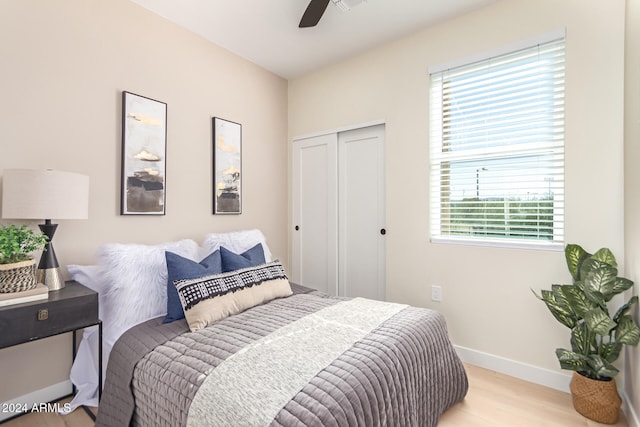 bedroom featuring ceiling fan, multiple windows, a closet, and light hardwood / wood-style flooring