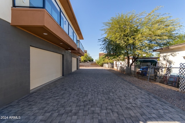 view of side of property featuring a garage and a balcony