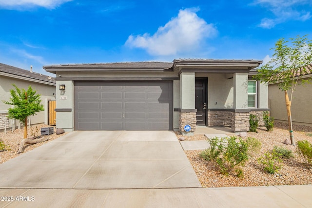 prairie-style house with an attached garage, concrete driveway, stucco siding, stone siding, and a tiled roof