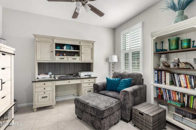 office featuring ceiling fan, built in study area, light tile patterned floors, and baseboards
