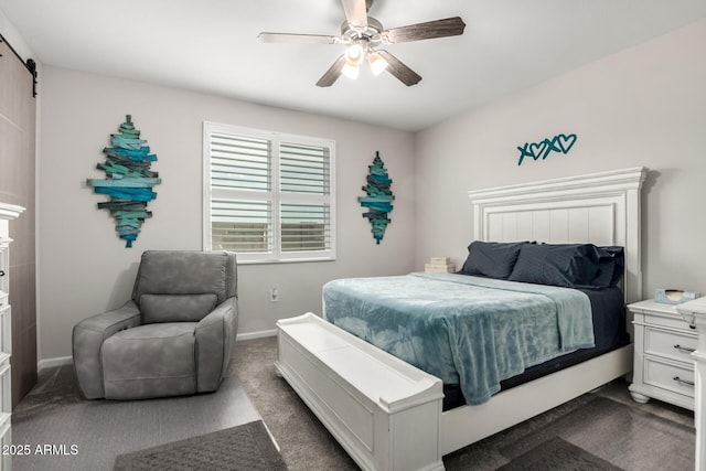 bedroom featuring dark colored carpet, a barn door, a ceiling fan, and baseboards