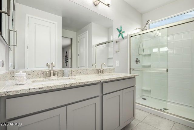 bathroom featuring a stall shower, tile patterned flooring, and double vanity