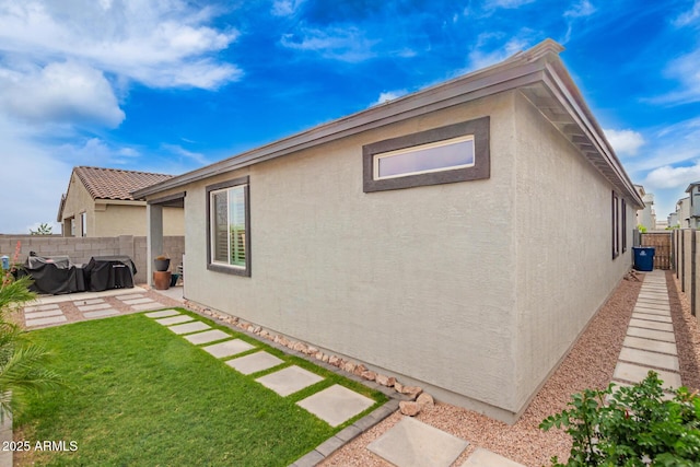 back of house with stucco siding and a patio area