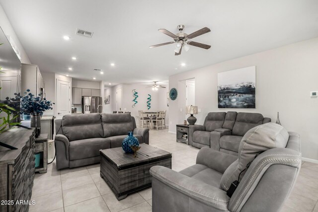 living area with a ceiling fan, recessed lighting, light tile patterned floors, and baseboards