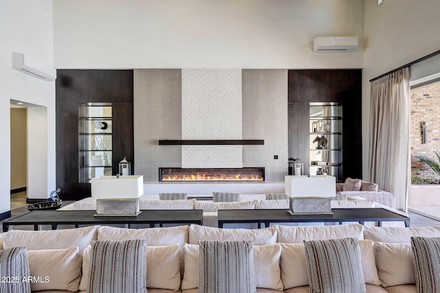 living room with a wall mounted air conditioner, a fireplace, and a wealth of natural light