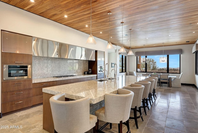 kitchen with wooden ceiling, stainless steel appliances, hanging light fixtures, and a large island